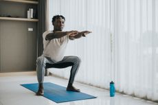 Man doing squat exercise at home