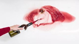 a woman pouring wine down the sink to lose belly fat