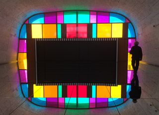Panels in various colors frame the rectangle shape mirror. The photo is taken from the back.