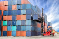 A stack of colourful containers being built up by a forklift truck