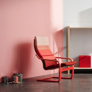 living area with pink and white wall red shaded armchair and dark grey floor