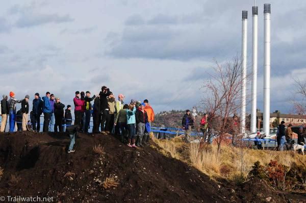 Spectators watch from a ridge with the old Sawmill in the background