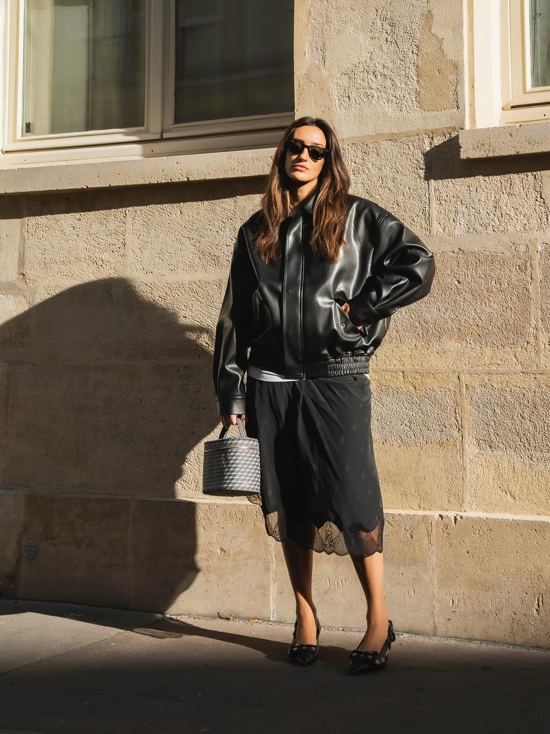 Kenza Sadoun el Glaoui wearing a black leather bomber jacket with a lace-trim midi skirt.