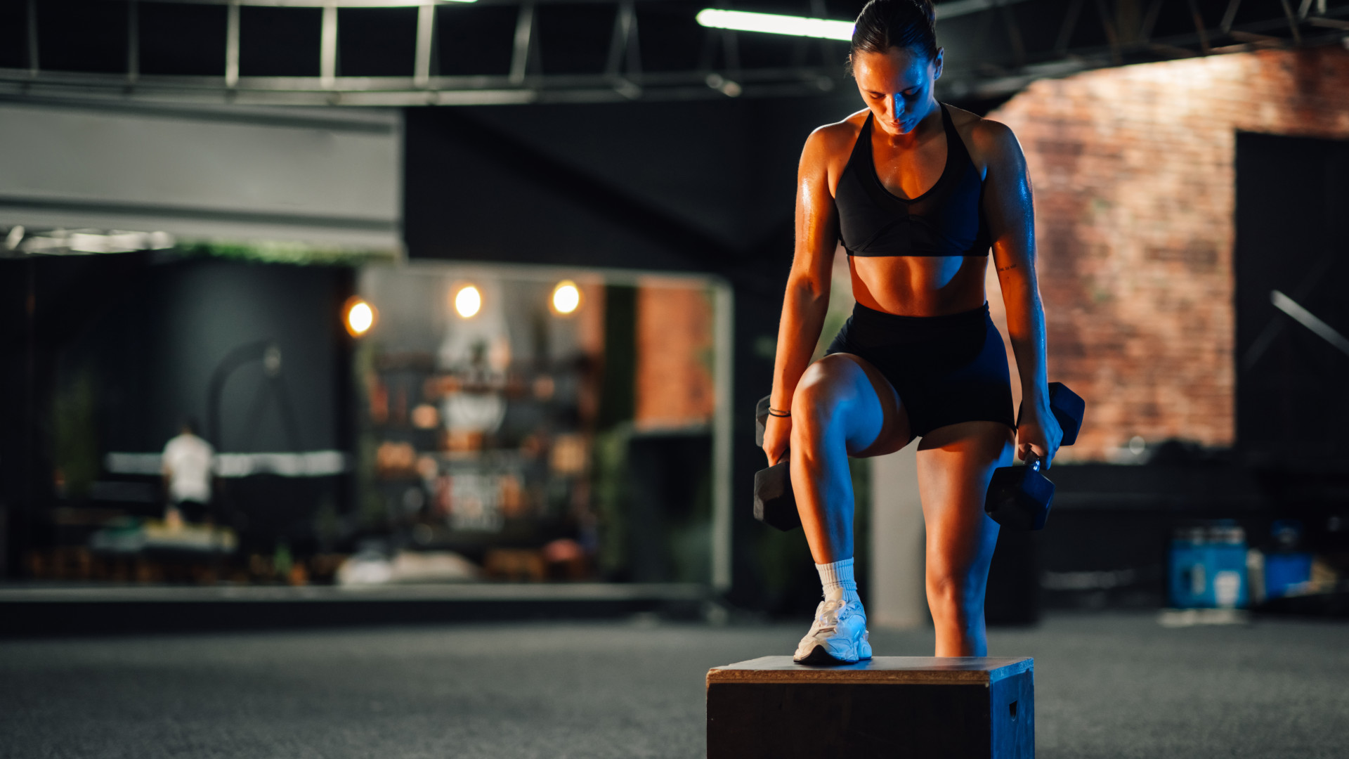 A girl doing dumbbell box step ups