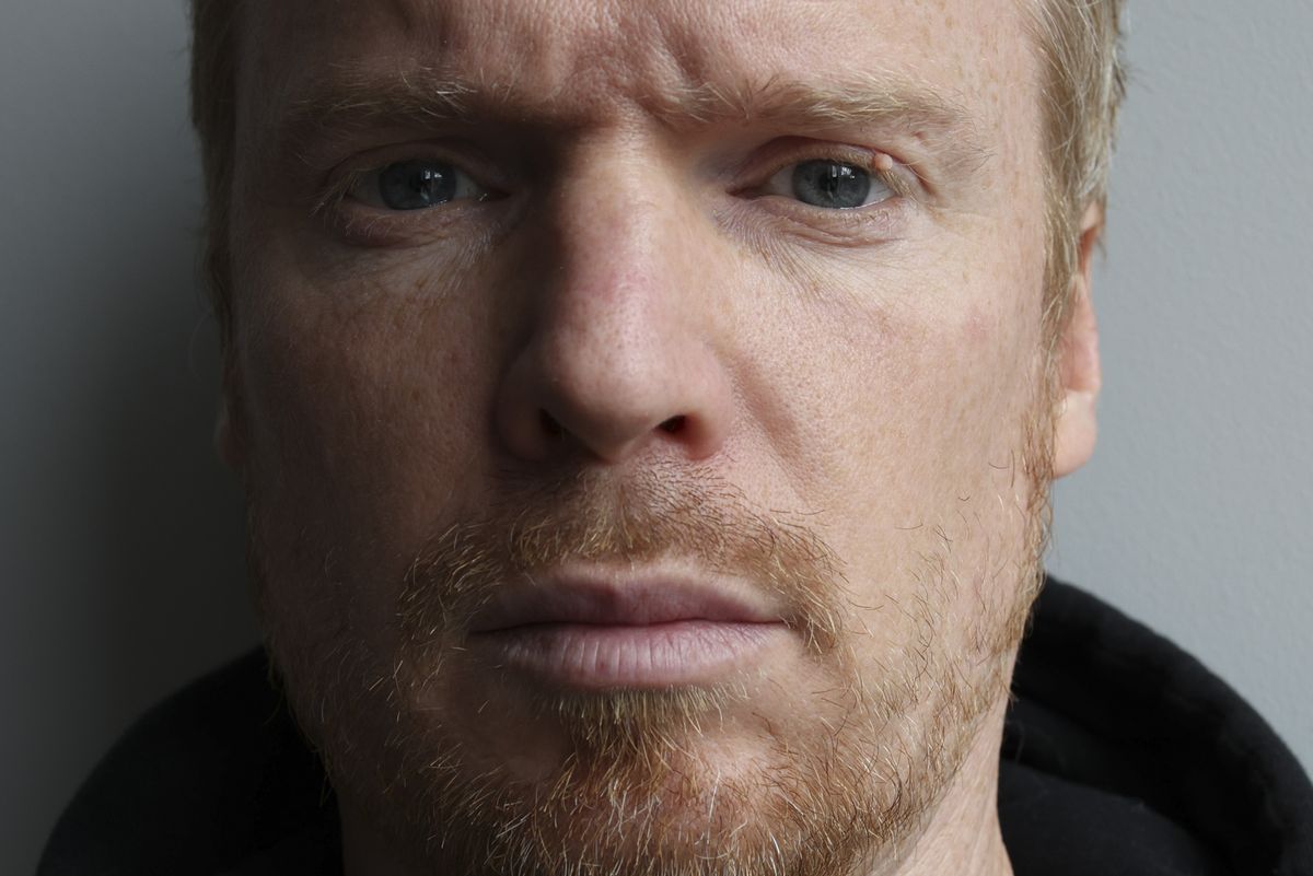 A self portrait against a plain gray wall taken with the Canon RF 35mm F1.4L