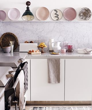 Pictures of kitchens showing a white and pastel pink scheme with plates on display on an open shelf.