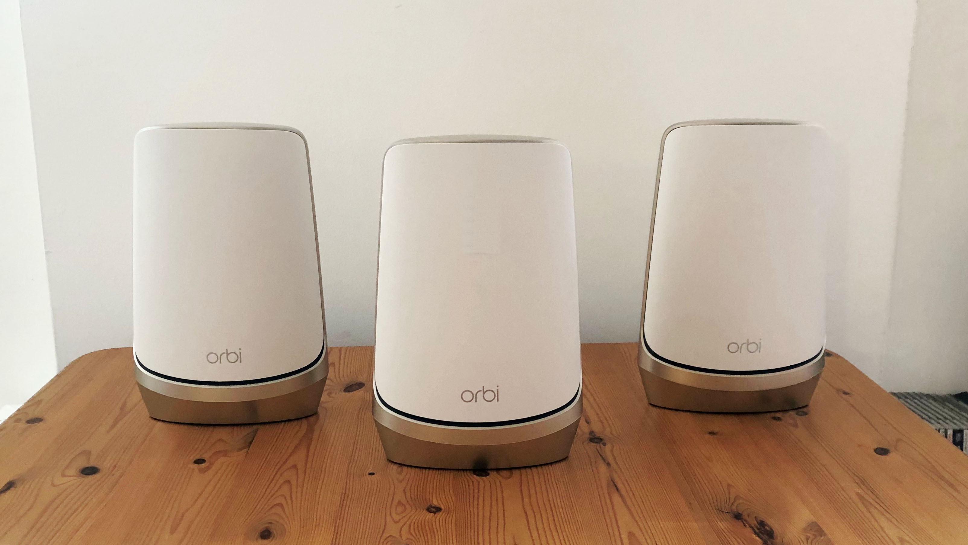 best mesh Wi-Fi system Netgear Orbi Quad-Band WiFi 6E on a wooden table