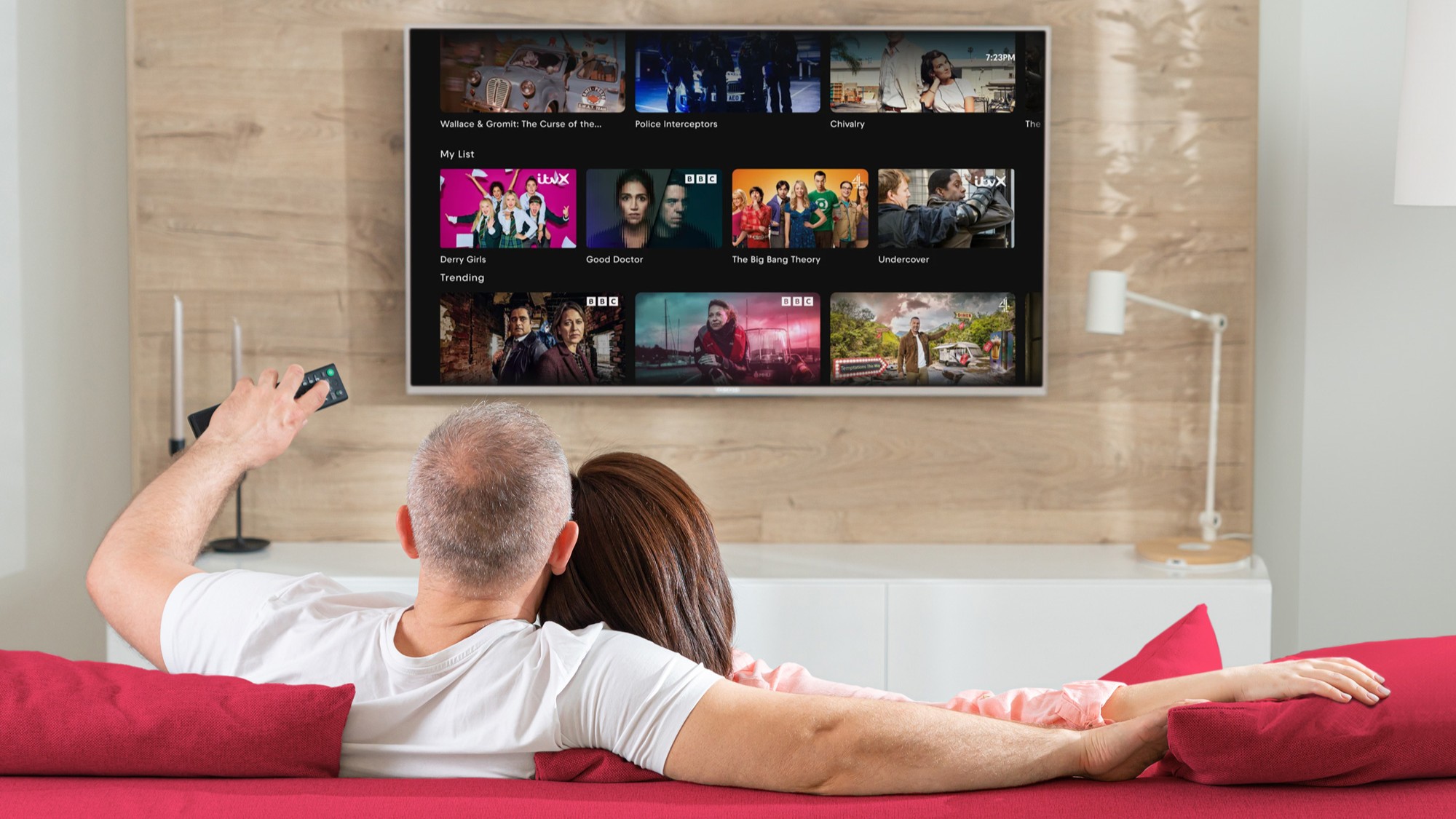 A couple sat on a couch scrolling through their list on Freely