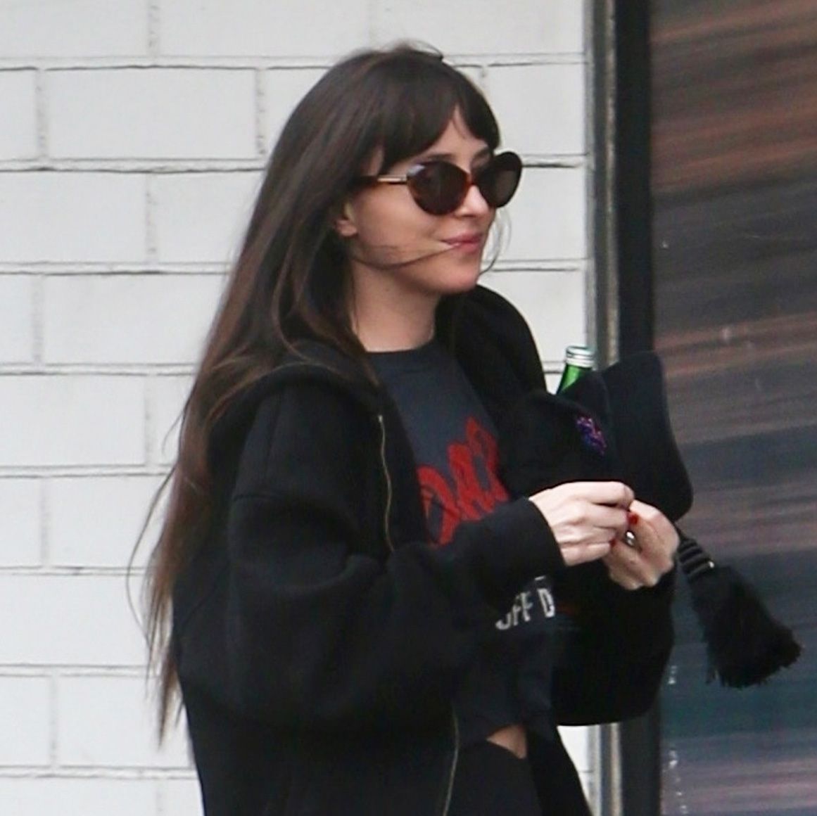 Dakota Johnson wearing sweatpants over leggings