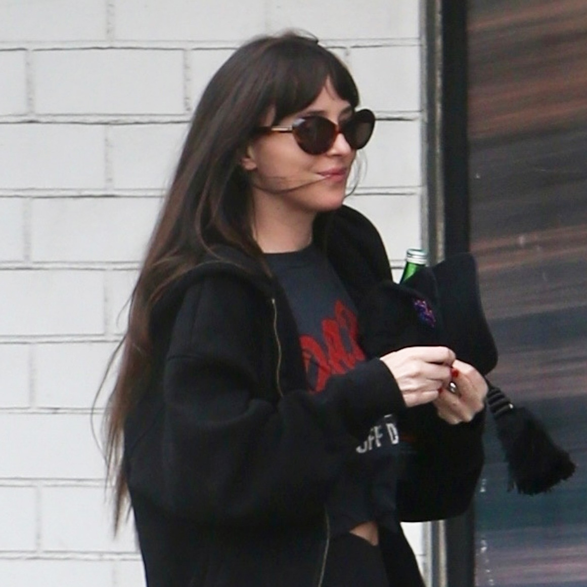 Dakota Johnson wearing sweatpants over leggings