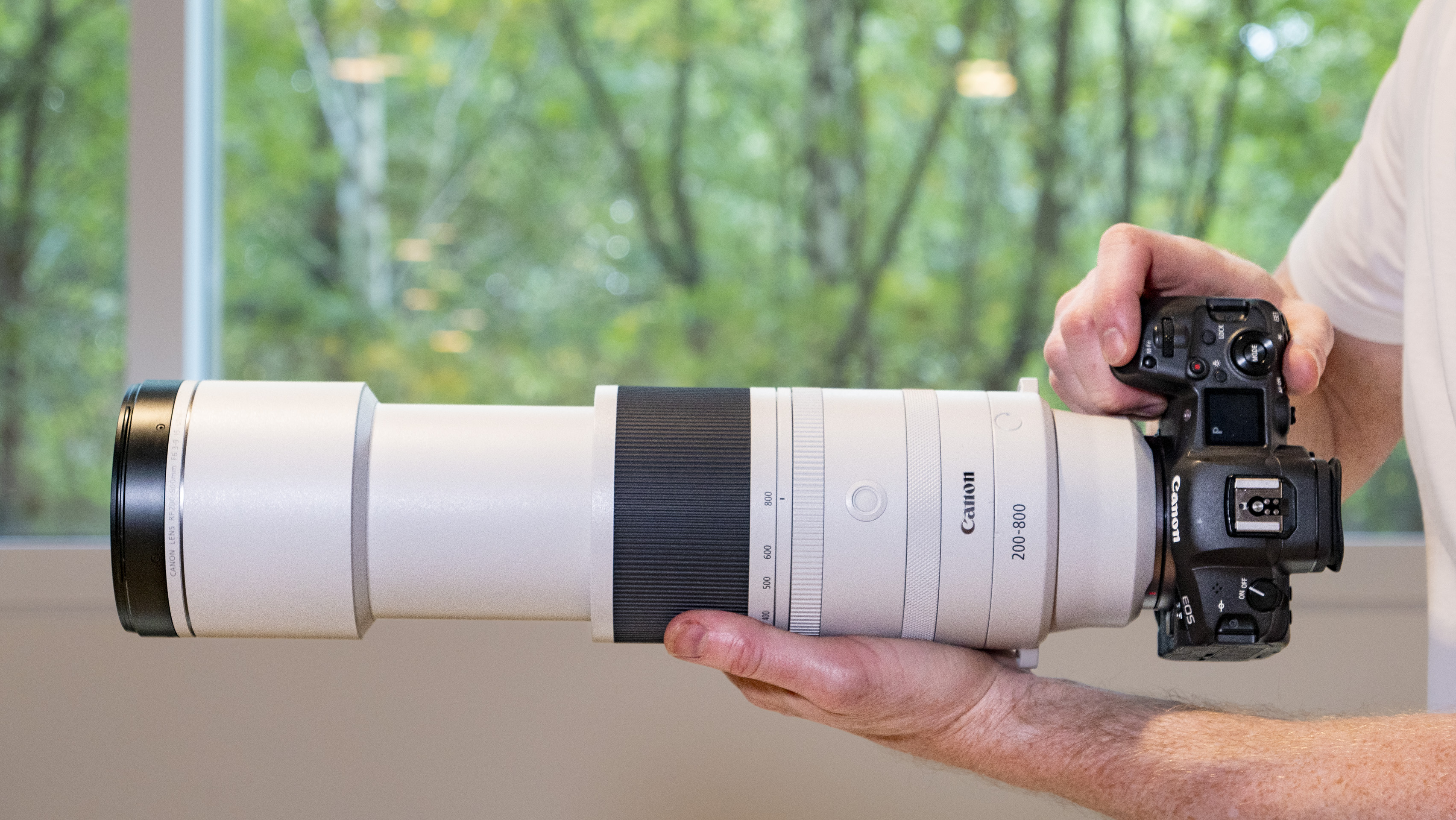 Canon RF 200-800mm F6.3-9 lens in the hand set to 800mm, mounted to a Canon EOS R5