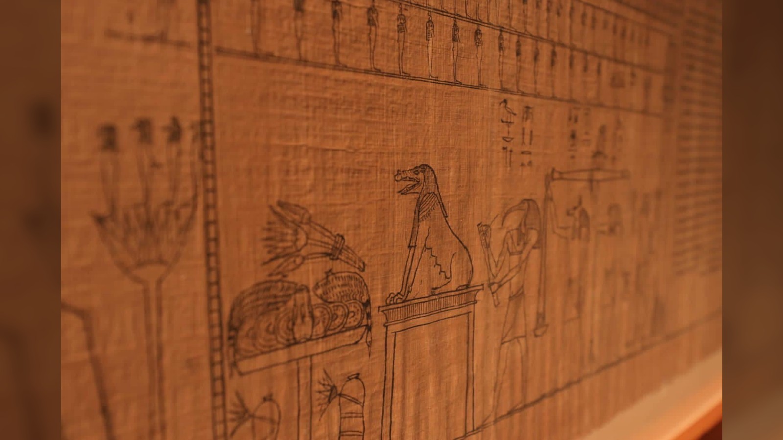 This close-up from the Book of the Dead shows a creature (with a long snout and sitting back on its hind legs like a dog,), possibly Ammit, sitting before Osiris, the Ancient Egyptian god of the underworld.