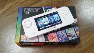Evercade EXP review; a white handheld games console on a wooden table on a box