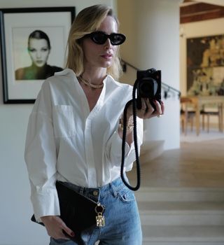 Woman wearing a white button-down and jeans.