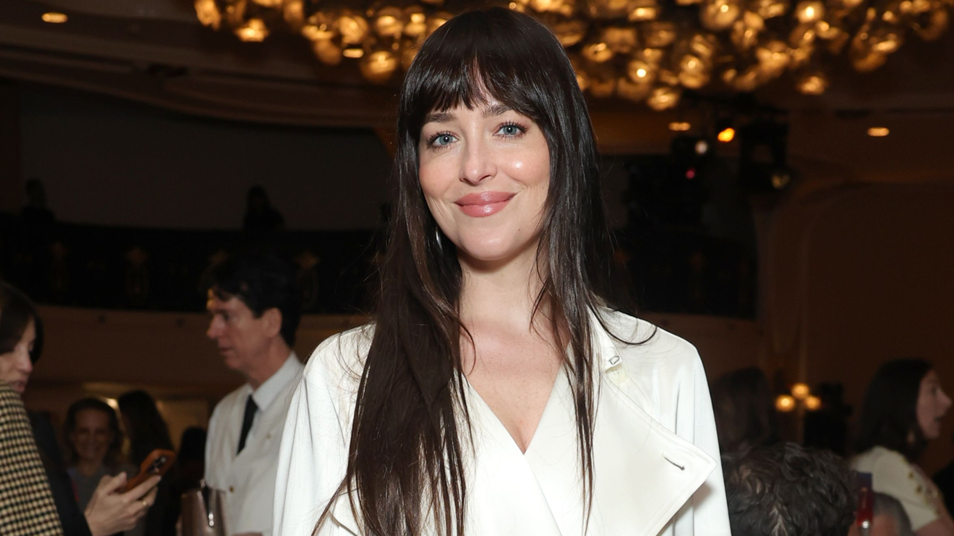 Dakota Johnson delivered holiday party dressing inspiration in a white satin trench coat