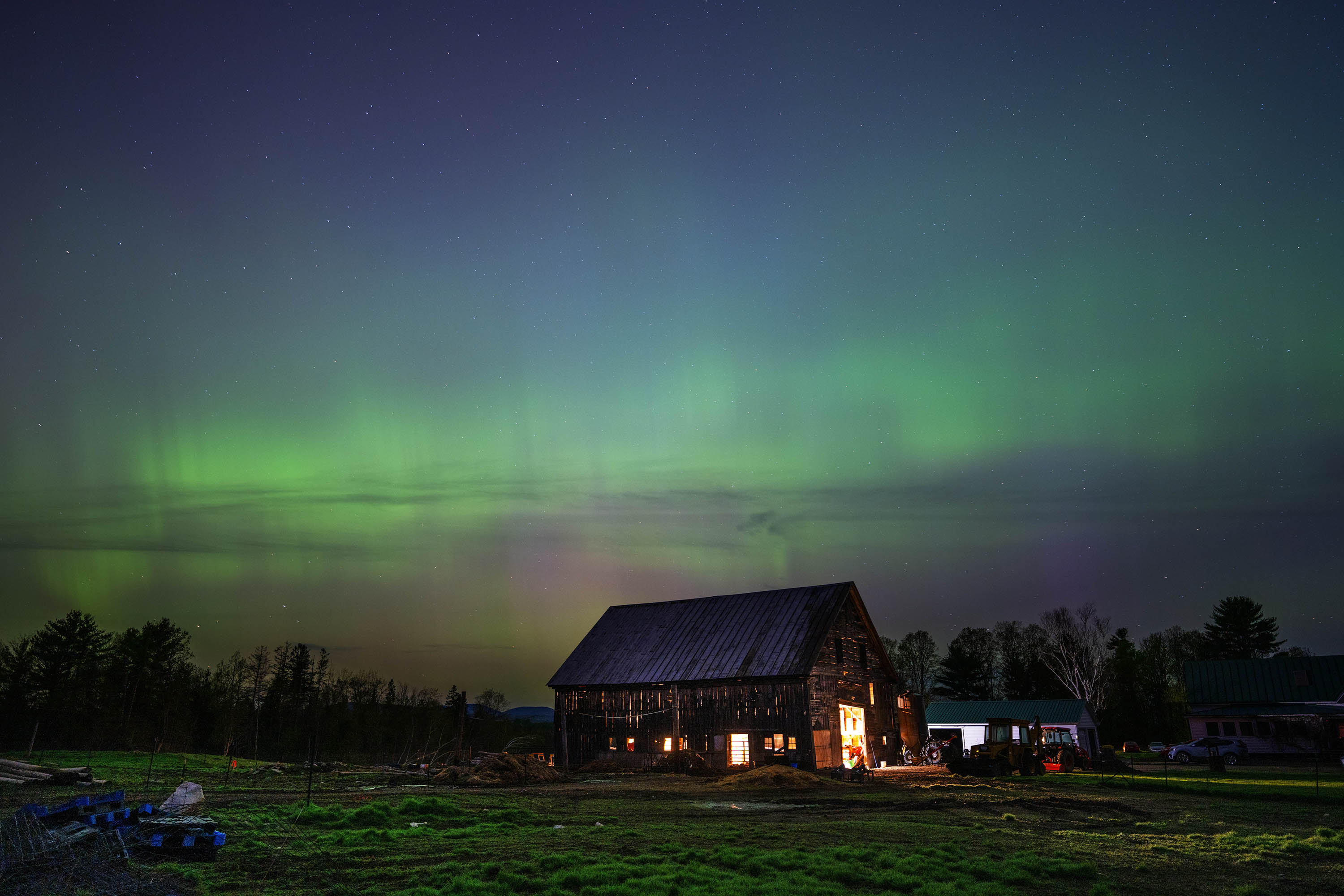 The northern lights fill the sky with green ribbons over a barn in Mercer, Maine.