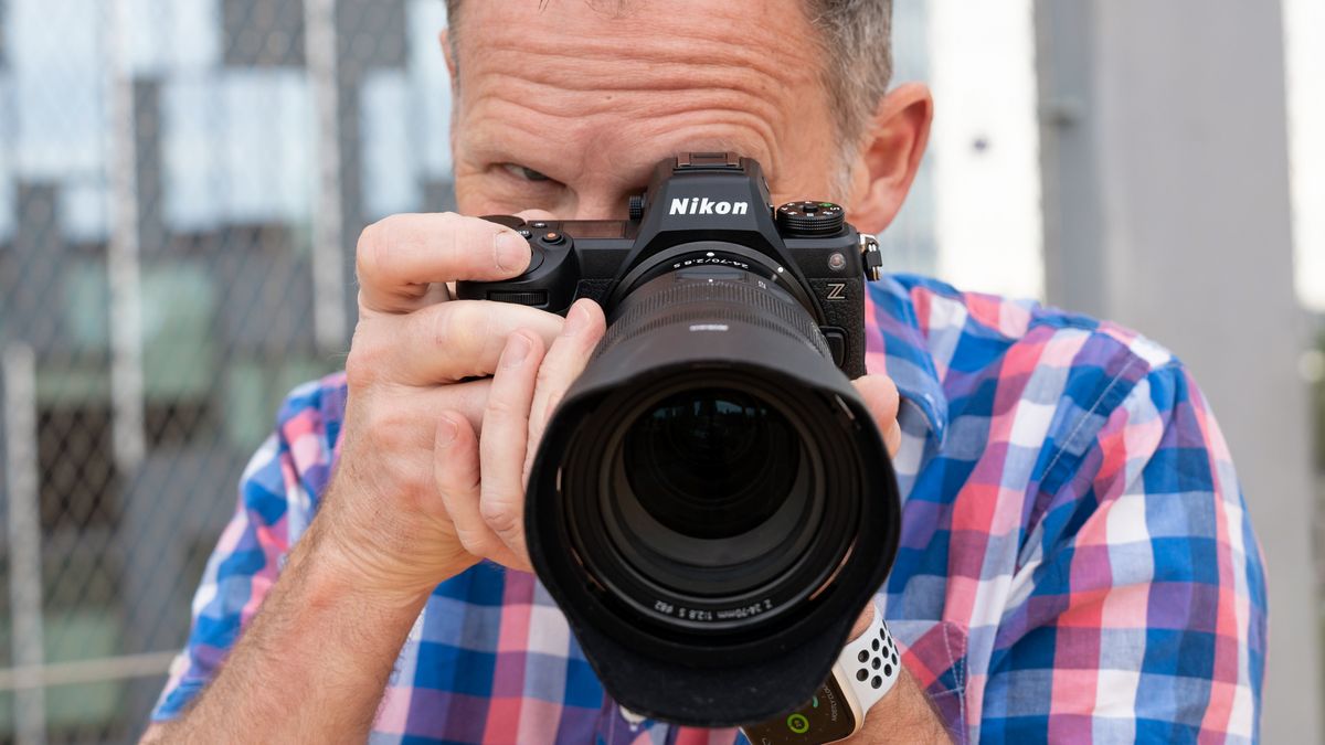 Person holding a Nikon Z6 III camera up to their face