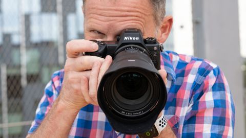 Person holding a Nikon Z6 III camera up to their face