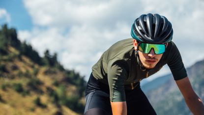 Male cyclist riding in the mountains, wearing a pair of the best cycling glasses for cycling