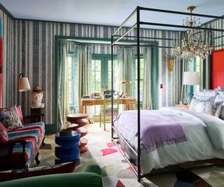 Striped wall bedroom with central four poster bed