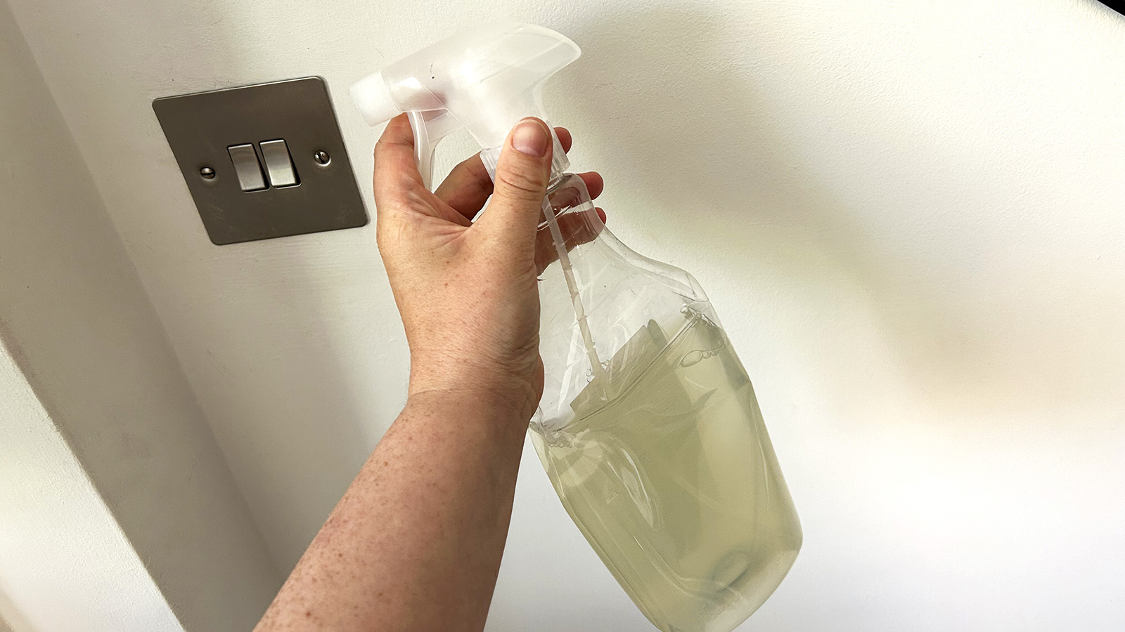 Homemade cleaning spray against a white wall