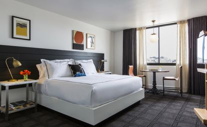 Hotel room with frames on wall and white bed linen