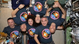 The six-member Expedition 61 crew, wearing T-shirts printed with the crew insignia, gathers for a playful portrait inside the International Space Station's Zvezda service module. Pictured from left to right are flight engineers Andrew Morgan, Oleg Skripochka, Jessica Meir, Christina Koch and Alexander Skvortsov and Cmdr. Luca Parmitano. 