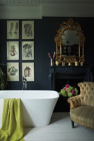 dark coloured bathroom with a moody feel, decorated eclectically with a freestanding bath