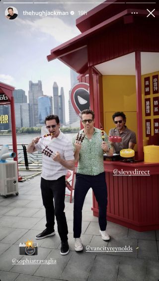 Hugh Jackman and Ryan Reynolds posing with meat sticks