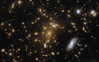 A monstrous cluster of galaxies lurks at the heart of this Hubble Space Telescope image.