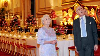 Queen Elizabeth II, accompanied by Sir Hugh Roberts, the Director of the Royal Collection, views the Summer Opening exhibition at Buckingham Palace where the Ballroom has been set out so that visitors can experience a State Banquet