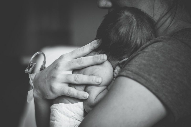 A black-and-white photo of a woman holding a baby.