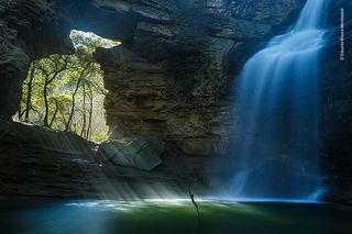 Painted Waterfall by Eduardo Blanco Mendizabal, Spain When the sun beams through a hole in the rock at the foot of the La Foradada waterfall, Catalonia, Spain, it creates a beautiful pool of light. The rays appear to paint the spray of the waterfall and create a truly magical picture.