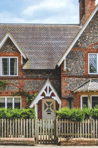 brick and flint cottage with front door canopy with pillars