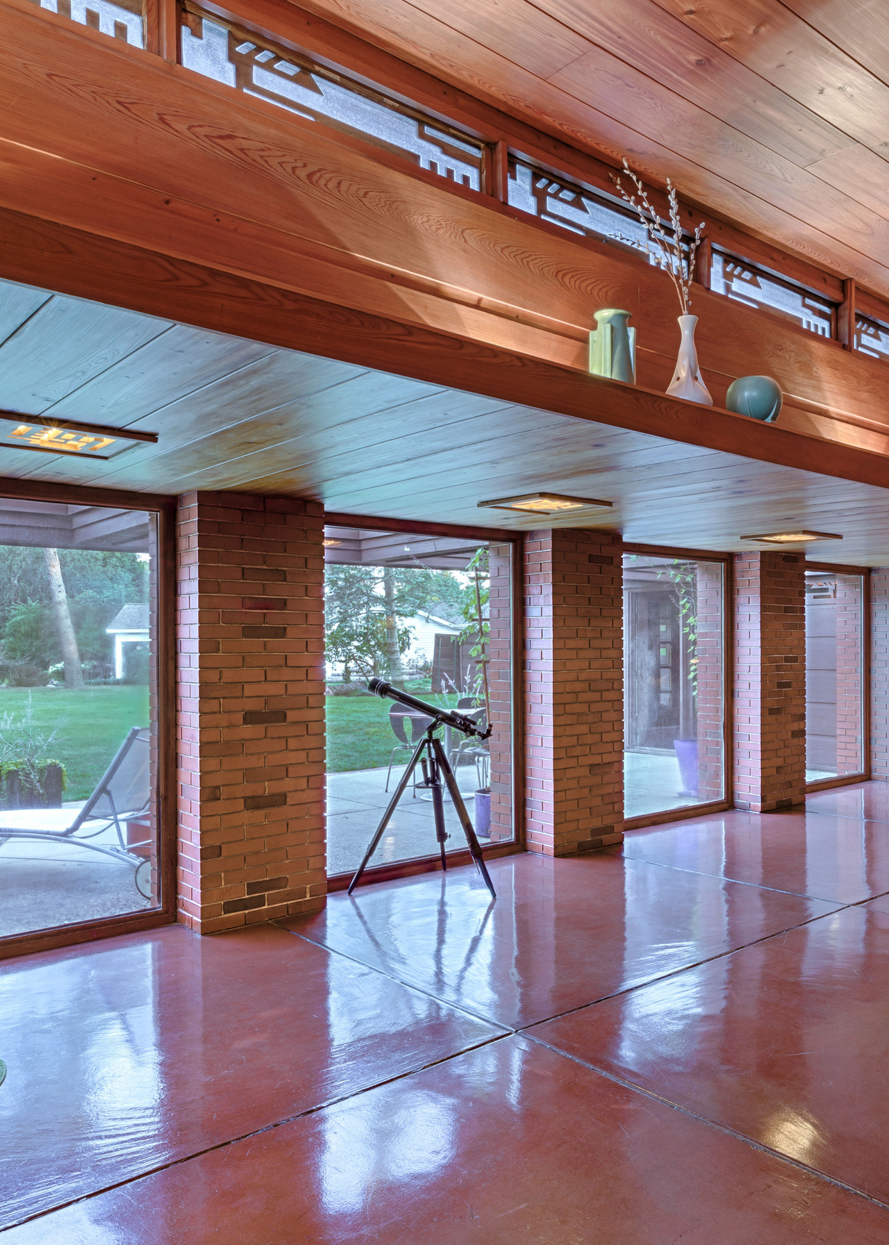 frank lloyd wrights schwartz house, a microscope by a wall of glass windows, beneath a wooden panelled ceiling