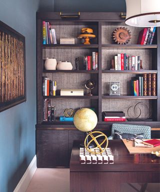 Dark walled home office, desk, bookcases, office accessories, blue walls, carpet