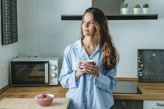 woman tired after having vivid dreams in lockdown, holding coffee
