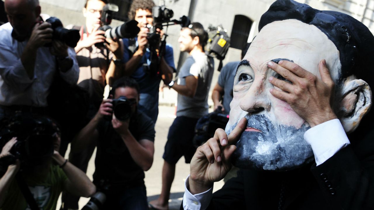 A protester wearing a mask depicting Spanish PM Mariano Rajoy outside Spain&amp;#039;s national court 