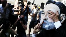 A protester wearing a mask depicting Spanish PM Mariano Rajoy outside Spain's national court 