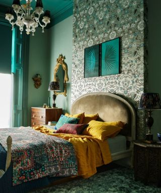 Moody bedroom painted in dark green with hints of yellow and golds