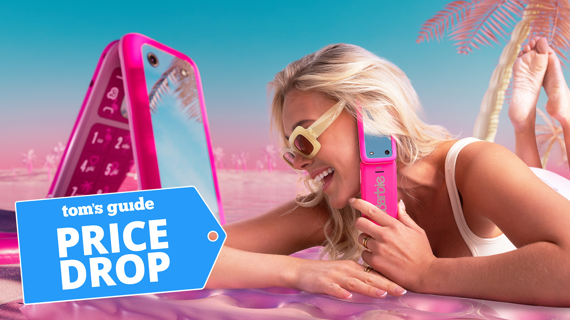 HMD Barbie Phone promotional image with woman on a pink beach using the phone with 'Price Drop' badge overlaid