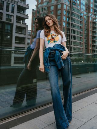 Actress Ella Hunt pays homage to comedy legend Gilda Radner wearing a white t-shirt with Minnie Mouse on the front and high-waisted wide-leg jeans.