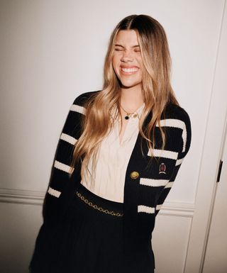 sofia richie grainge wears a striped cardigan and pleated mini skirt in new holiday campaign for tommy hilfiger