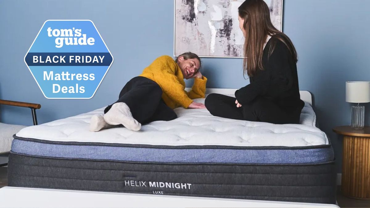 The image shows two women laying and sitting on top of the Helix Midnight Luxe mattress