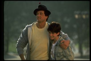 Sylvester Stallone with his arm around Sage Stallone in a still from Rocky V