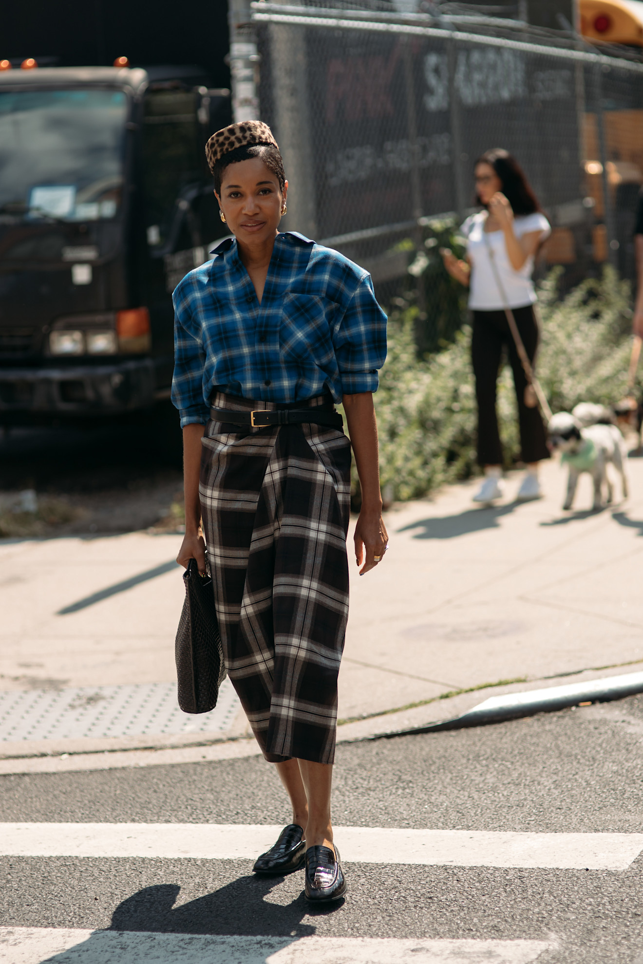 A guest wearing a plaid shirt and skirt at the COS F/W 25 show during NYFW.