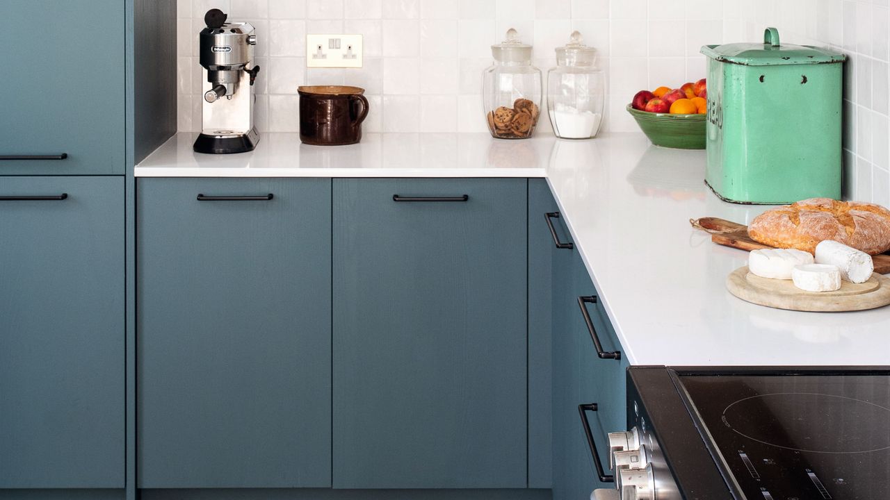 Blue painted kitchen cabinets and dark handles, decorated kitchen worktop