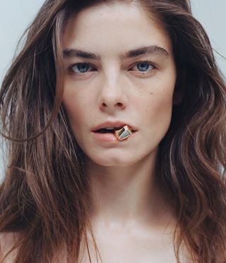 Model holds ring in mouth