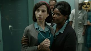 A film still from Searchlight Pictures The Shape of Water. Main character Elisa Esposito is being held by friend Zelda Fuller as they look beyond the frame