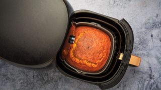 a cake cooking in an air fryer on a smooth kitchen countertop